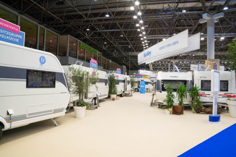 Messestand von Hobby mit Wohnwagen und dem Slogan „Gebaut fürs Leben“