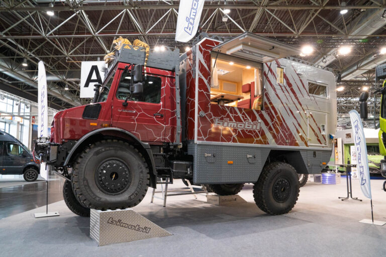 Rotes Expeditionsmobil von Bimobil auf Unimog-Fahrgestell mit geöffnetem Wohnaufbau