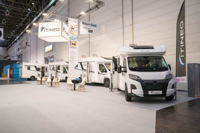 Messestand von Itineo mit mehreren weißen Teilintegrierten und dem Modell Cozi PM740