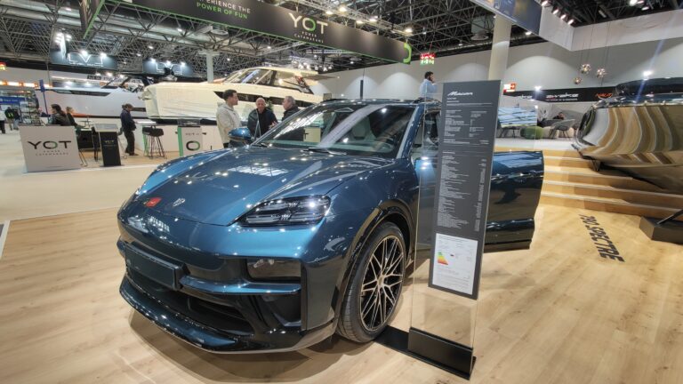 Blauer Porsche Macan Electric auf dem Messestand von YOT Power Catamarans