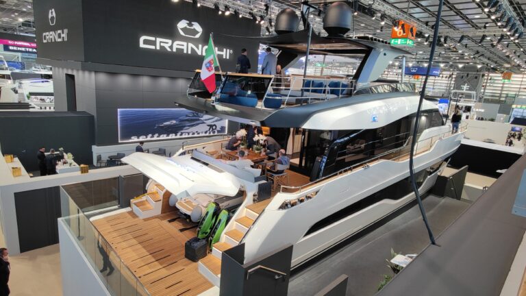 Cranchi Settantasette mit Flybridge und italienischer Flagge auf dem Messestand