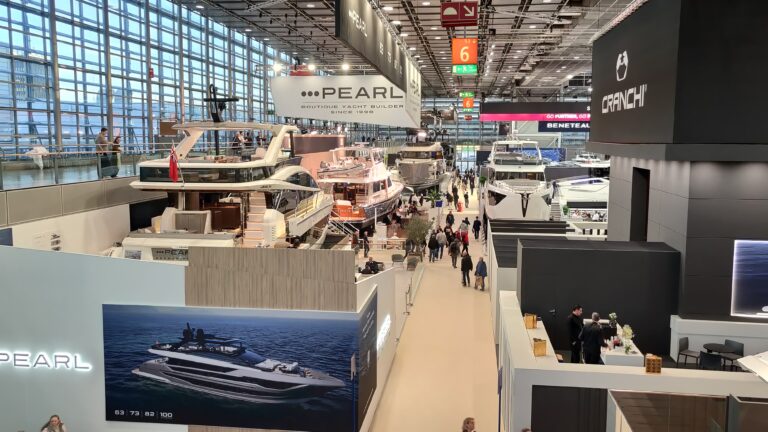 Blick von oben auf den Stand von Pearl Yachts mit mehreren Motoryachten und Besuchern im Gang
