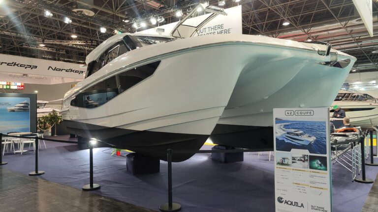 Weißer Motorkatamaran Aquila 42 Coupé aufgebockt auf dem Messestand